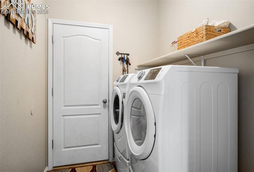 Washroom with washer and clothes dryer and hardwood / wood-style floors
