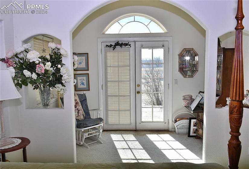 Foyer featuring light carpet and french doors