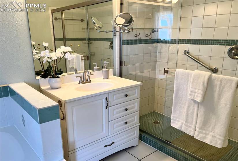 Bathroom featuring vanity, a shower with shower door, and tile floors