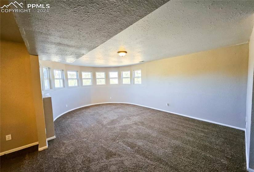 Spare room with dark carpet and a textured ceiling