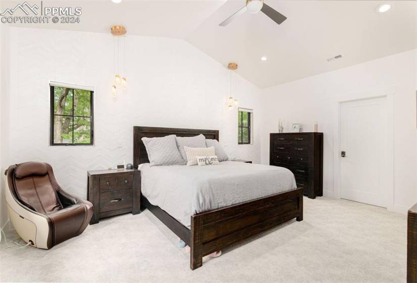 Bedroom with vaulted ceiling, ceiling fan, and custom textured tile accent wall