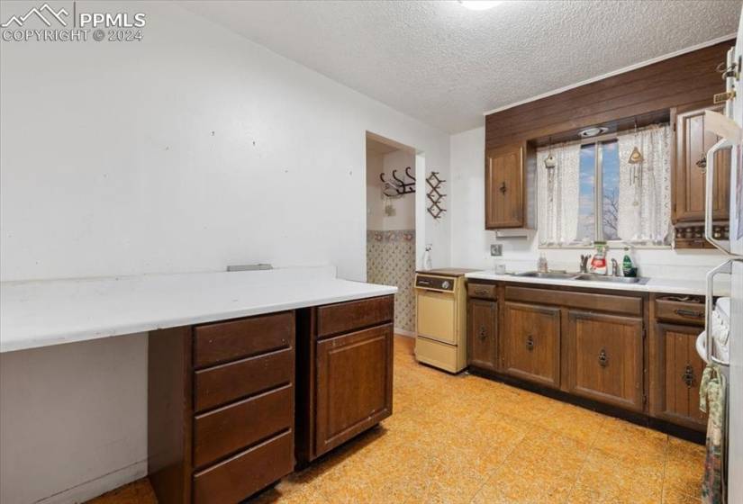 The Kitchen has vinyl floors, wood cabinets, and lots of counter space for food preparation and storage.