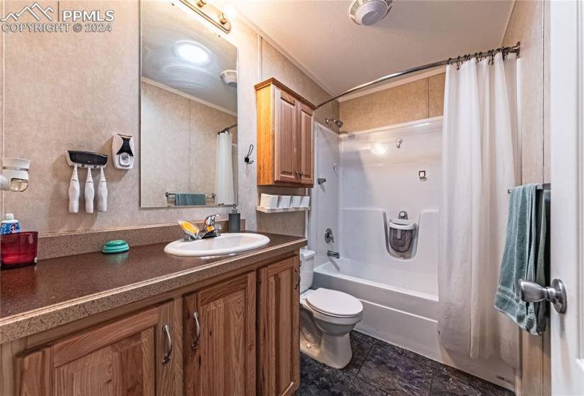 Full bathroom featuring ornamental molding, tile floors, shower / bath combo, oversized vanity, and toilet