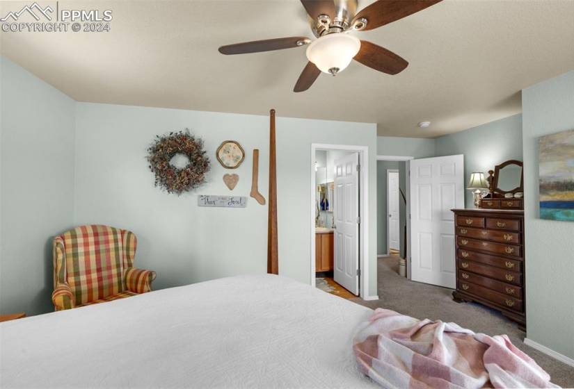 Bedroom with carpet, connected bathroom, and ceiling fan
