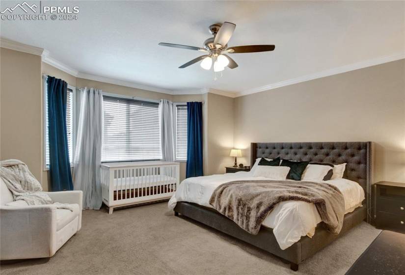 Bedroom featuring crown molding, light carpet, and ceiling fan