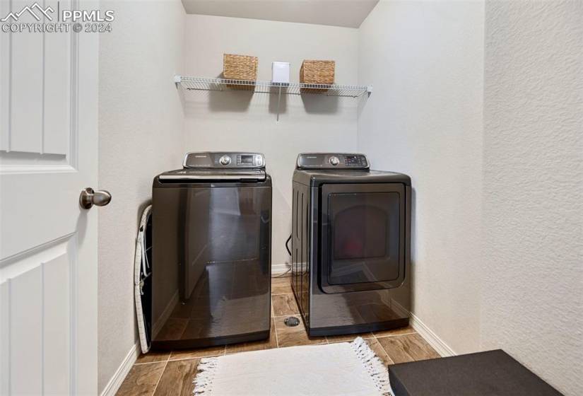 Laundry room with light tile floors and separate washer and dryer