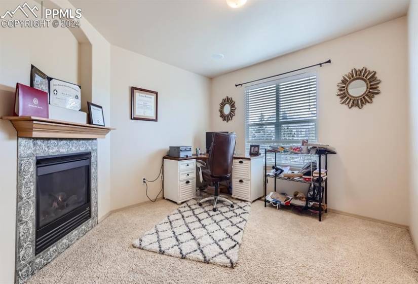 Carpeted office featuring a fireplace