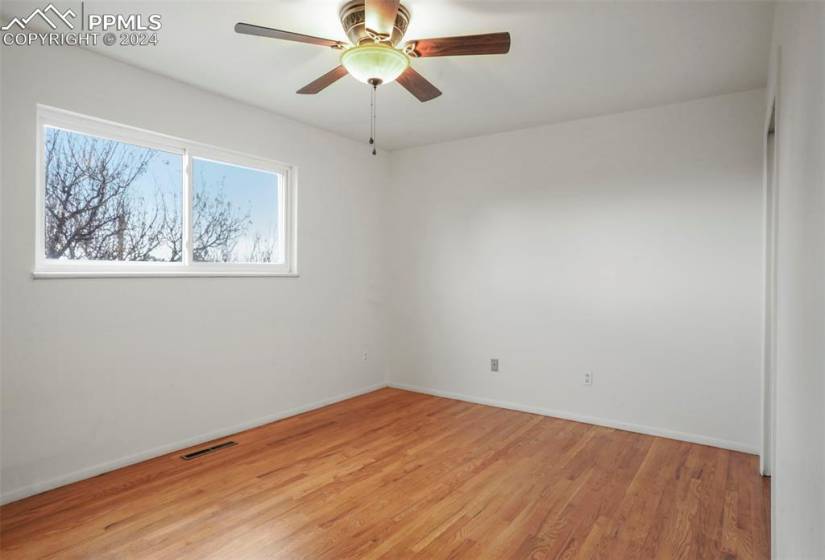 Spare room featuring light wood-type flooring, a healthy amount of sunlight, and ceiling fan