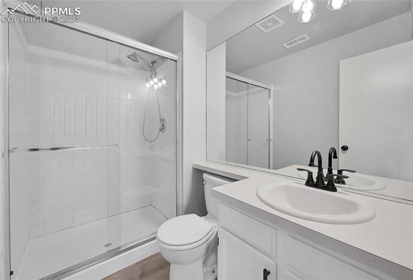 Bathroom featuring walk in shower, toilet, wood-type flooring, and oversized vanity