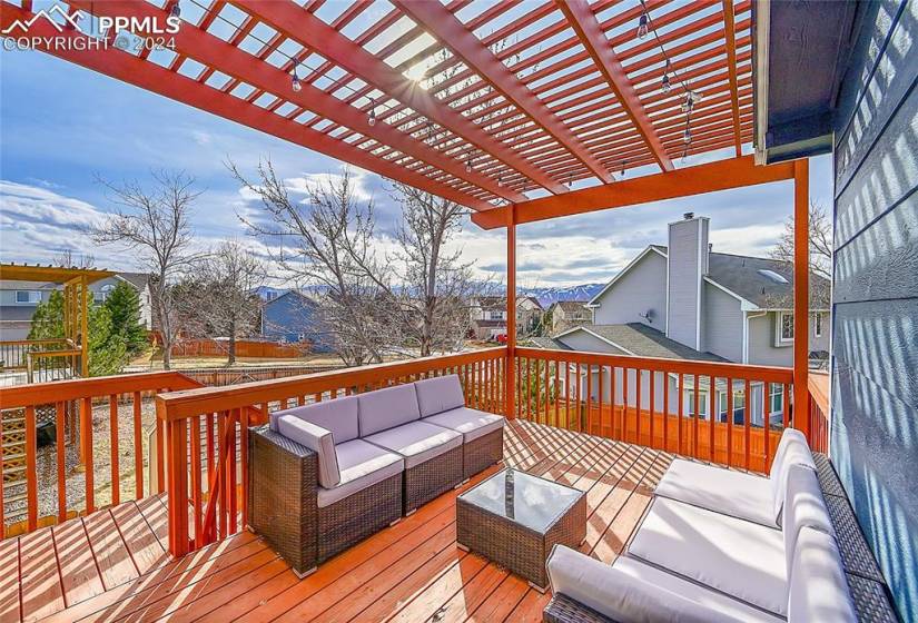 Wooden deck featuring an outdoor hangout area and a pergola