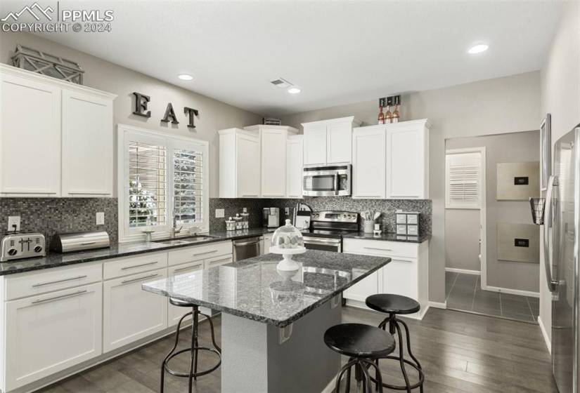Granite countertops and white cabinets adorn the gourmet kitchen, offering both beauty and functionality