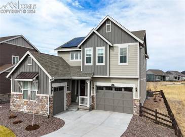 Craftsman-style home with a garage and solar panels