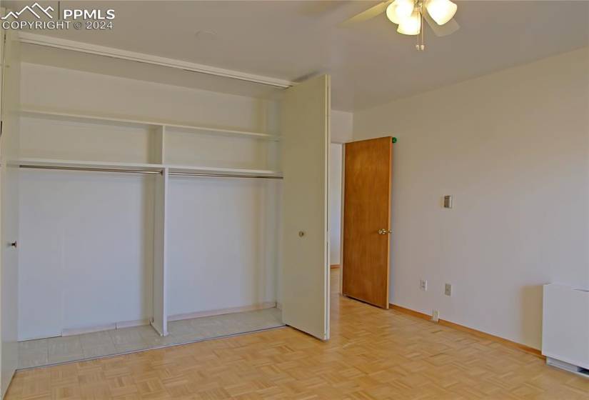 Unfurnished bedroom featuring light parquet flooring, a closet, and ceiling fan