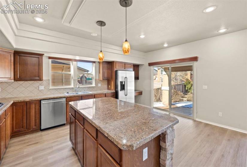 Kitchen featuring stainless steel appliances, tasteful backsplash, a center island, and a healthy amount of sunlight