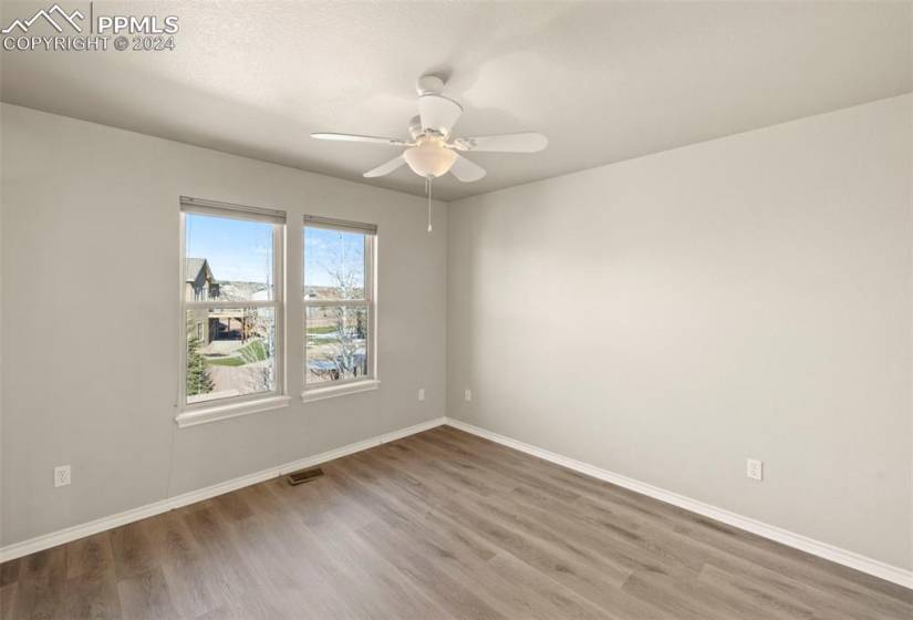 Empty room with light hardwood / wood-style floors and ceiling fan