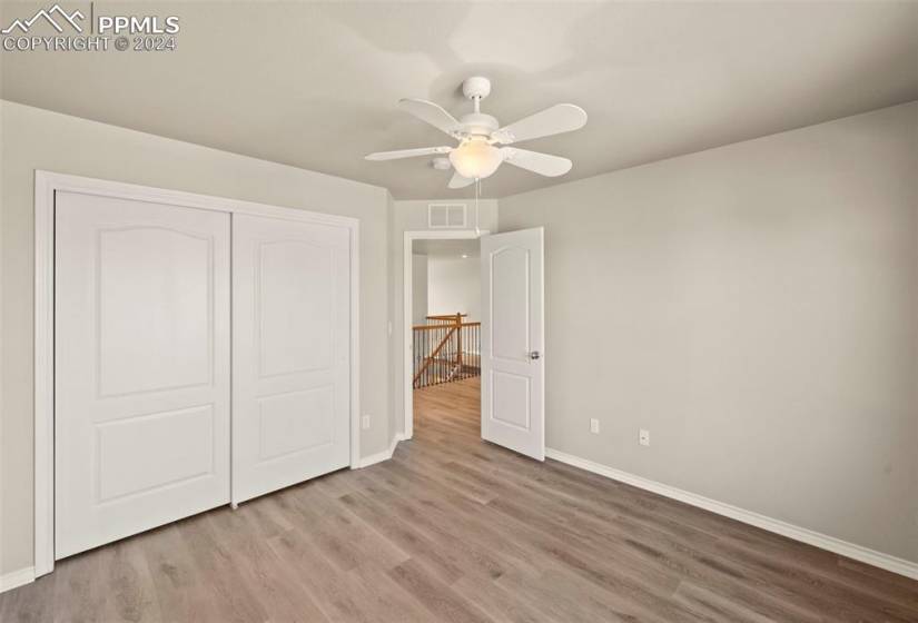 Unfurnished bedroom with light hardwood / wood-style flooring, a closet, and ceiling fan