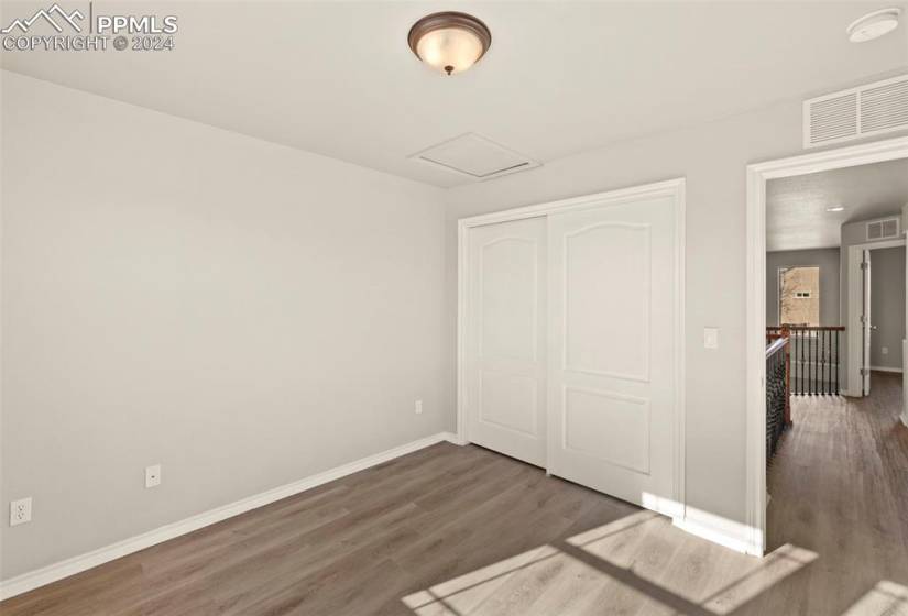 Unfurnished bedroom featuring dark hardwood / wood-style floors and a closet