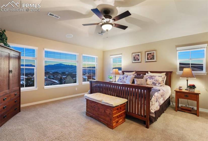Bedroom with lofted ceiling, light colored carpet, and ceiling fan