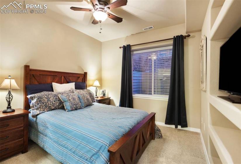 Basement Bedroom featuring light carpet and ceiling fan