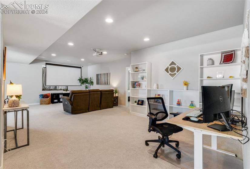 Office area & media room featuring light colored carpet