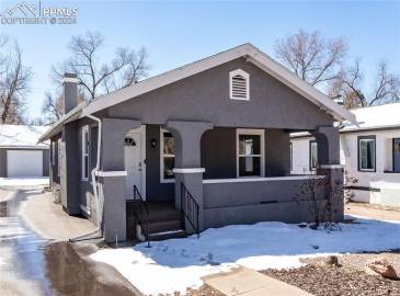 View of front of home featuring a 3-car garage and a covered porch