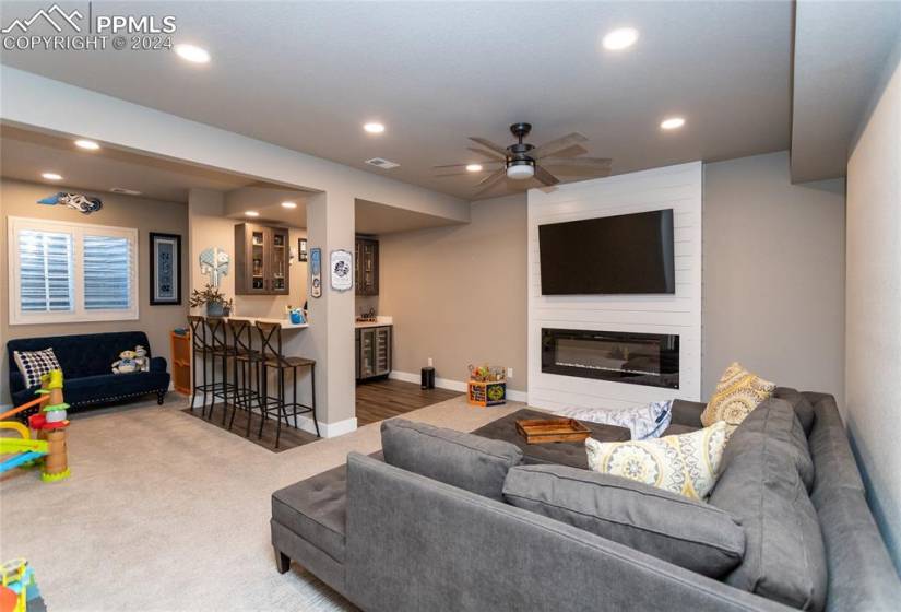 Basement family room with 9ft tall ceilings, color changing fireplace and full wet bar