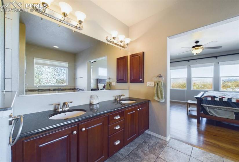 Bathroom with wood-type flooring, double sink vanity, and ceiling fan