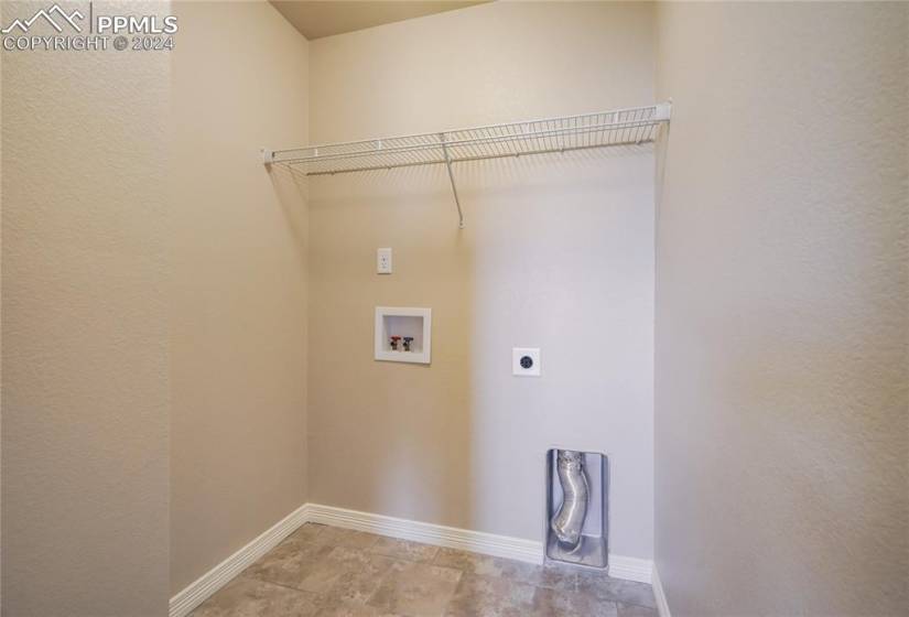 Upper-Level Laundry with Barn Door Entry for Ultimate Convenience | Shelving for Storage | Tile Floor