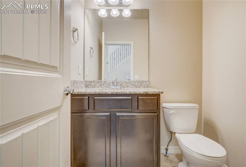 Main Level 1/2 Bathroom with Granite Countertop + Undermount Sink + Tile Floor