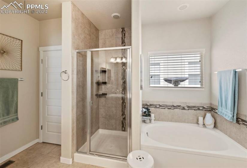 tub, shower, and linen closet in primary bathroom