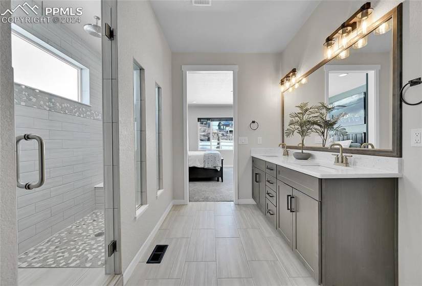 Bathroom with double sink vanity, walk in large spa-like shower, and tile flooring