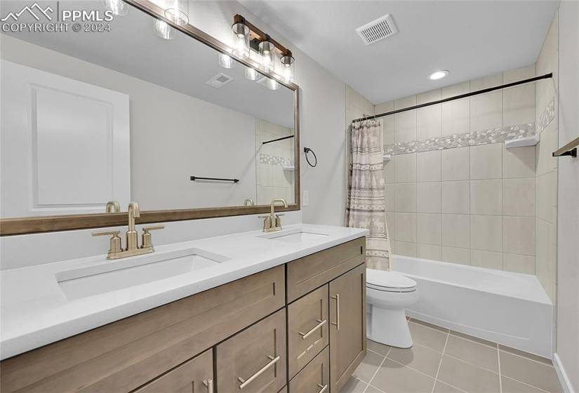 Full bathroom with large vanity, tile flooring, shower / bath combo dual sinks