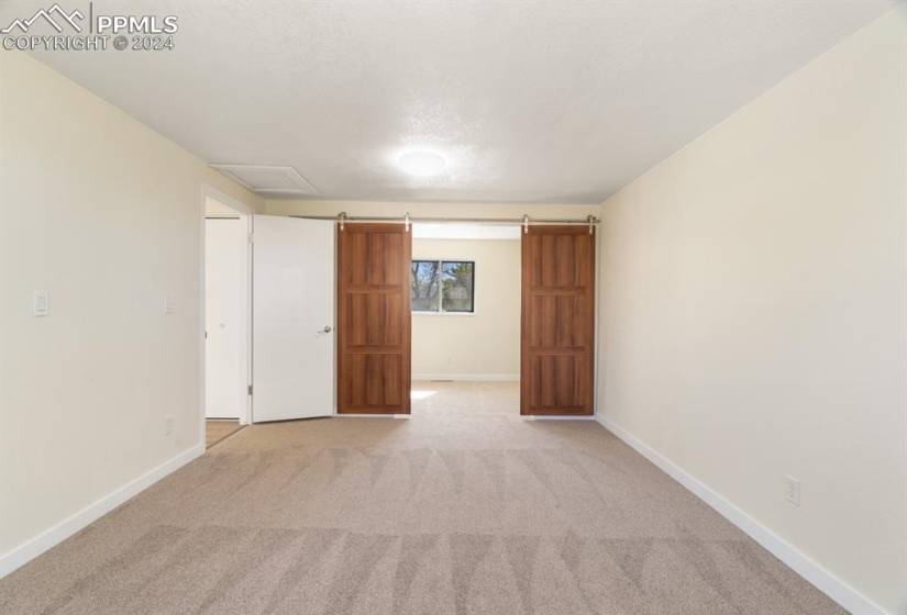 Carpeted empty room with a barn door