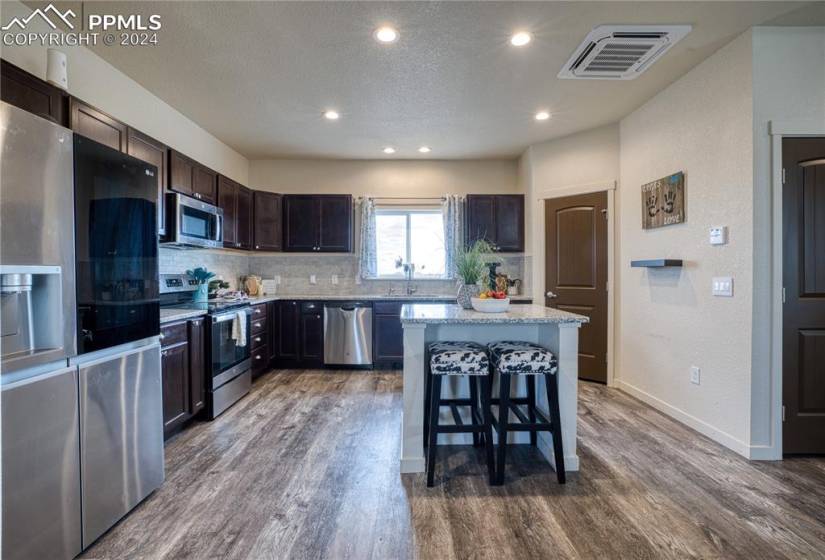 Spacious Island Kitchen, with walk in pantry, refrigerator, smooth top range oven, microwave, and dishwasher.