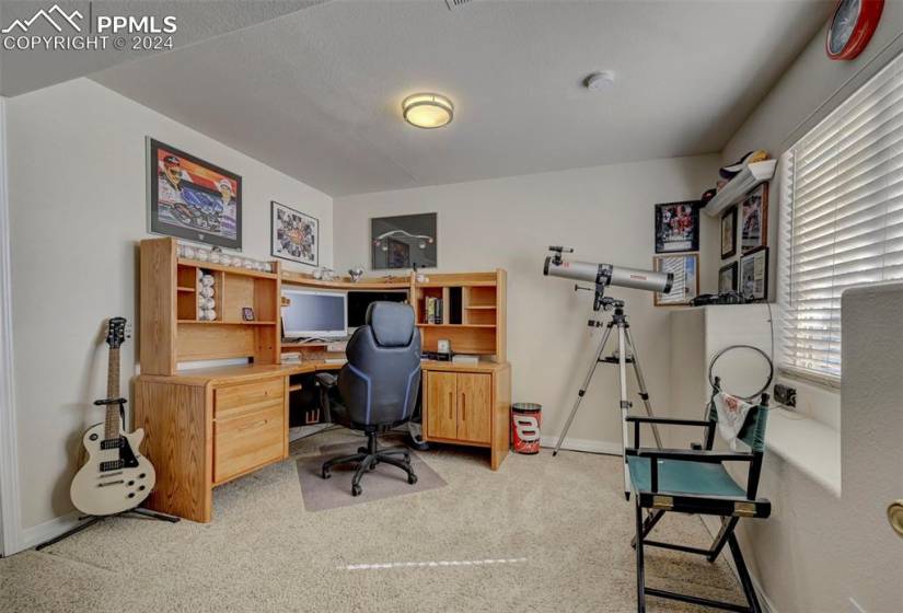 Carpeted home office with built in desk