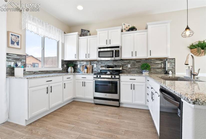 Kitchen featuring white cabinetry, tasteful backsplash, sink, and appliances with stainless steel finishes