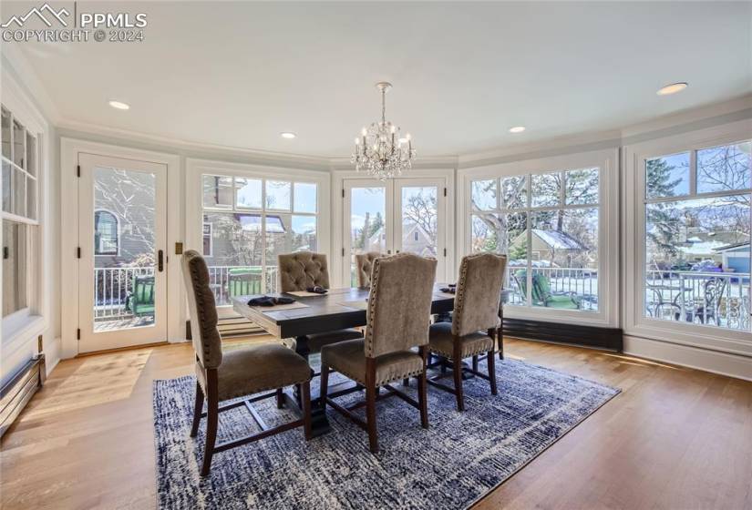 Dining area featuring light hardwood floors, crown molding, and a chandelier