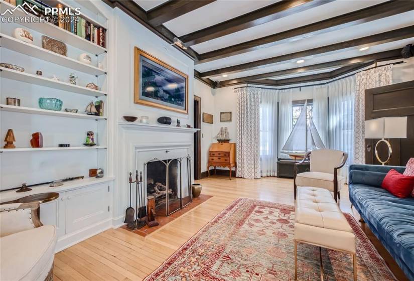 Living room with beamed ceiling and light hardwood floors