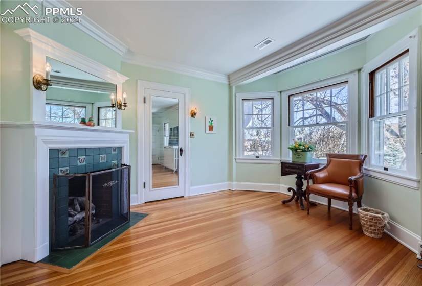 Living area with a fireplace, crown molding, and light hardwood floors