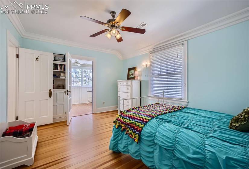Bedroom featuring crown molding, light hardwood flooring, and ceiling fan