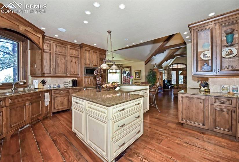Kitchen with sink, stainless steel microwave, cream cabinets, and dark wood-type flooring
