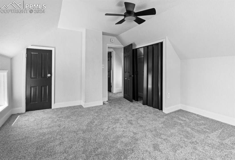 Bonus room with lofted ceiling, light carpet, ceiling fan, and a textured ceiling