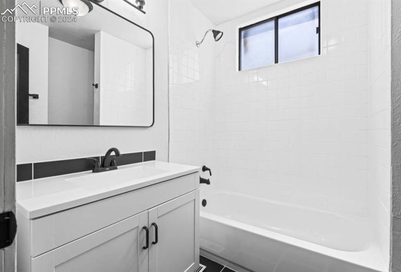Bathroom featuring tiled shower / bath combo and vanity