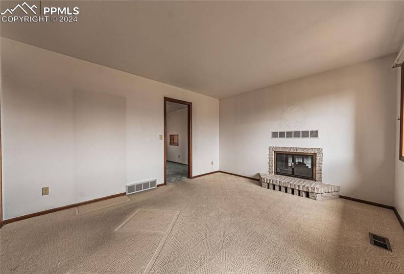 Unfurnished second bedroom or office room with carpet and a fireplace