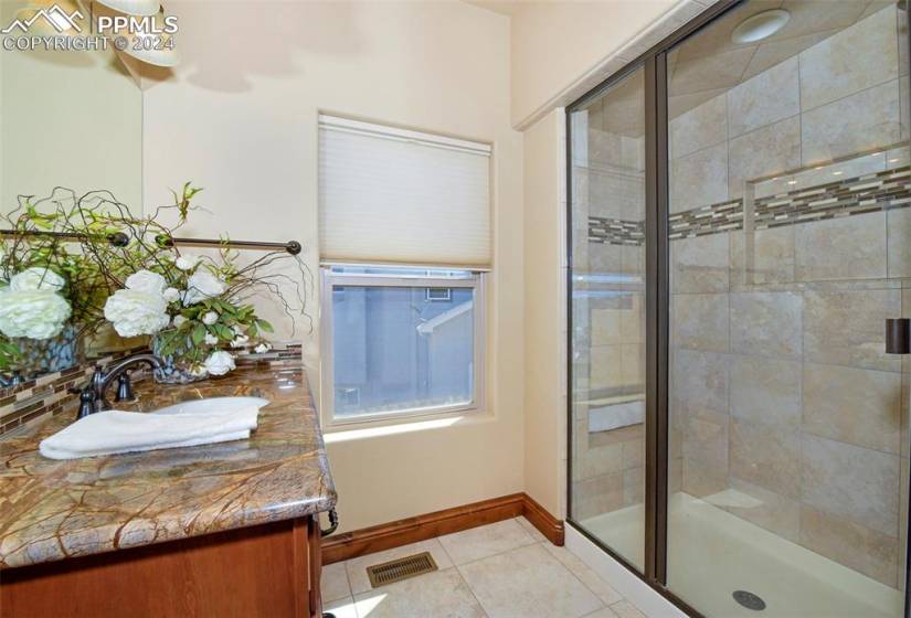 Bathroom featuring an enclosed shower, tile flooring, vanity, and a chandelier