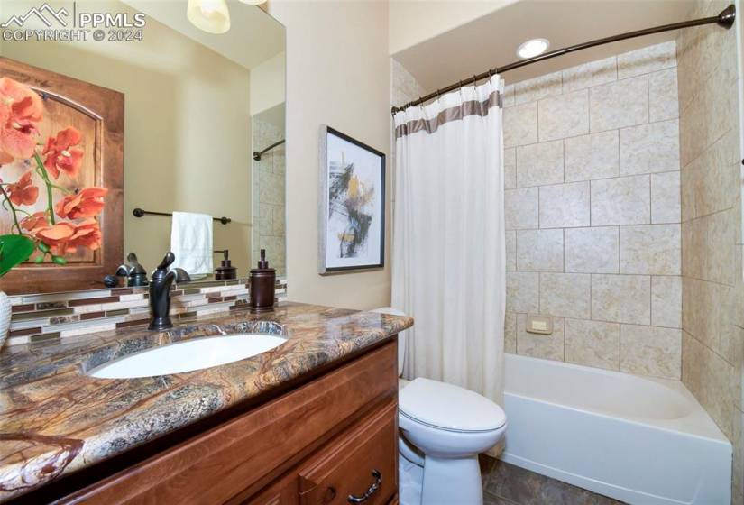 Full bathroom with vanity, toilet, tile flooring, and shower / bath combination with curtain