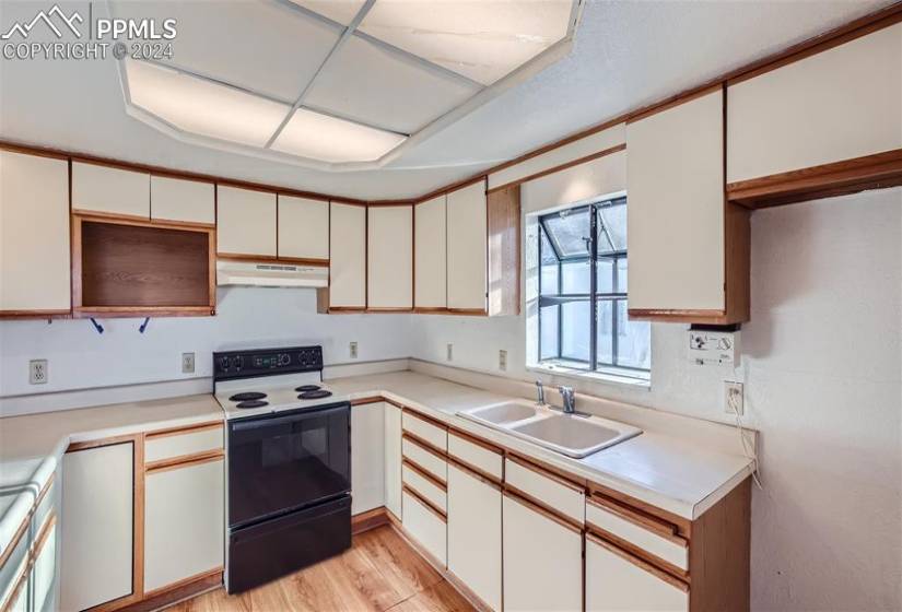 Kitchen featuring sink, white cabinetry, white range with electric cooktop, and light hardwood / wood-style flooring