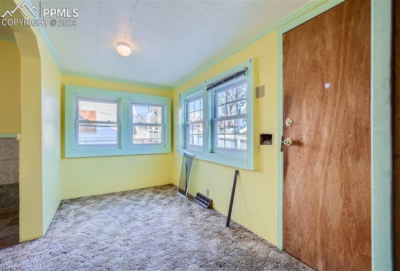 Unfurnished room with crown molding, a wealth of natural light, and carpet