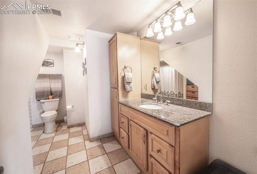 Bathroom featuring tile floors, large vanity, and toilet