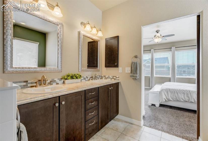 Primary bathroom features dual sinks, counter-height vanity, and tile floor.